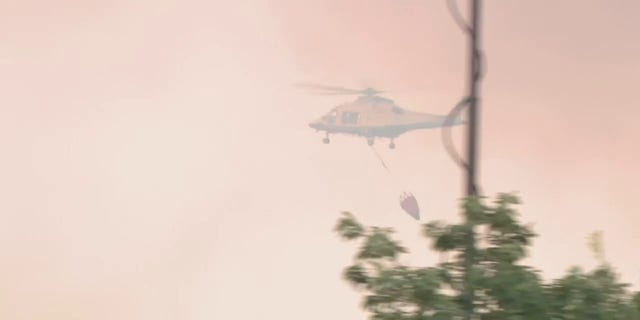 Helicopter dropping water on fire