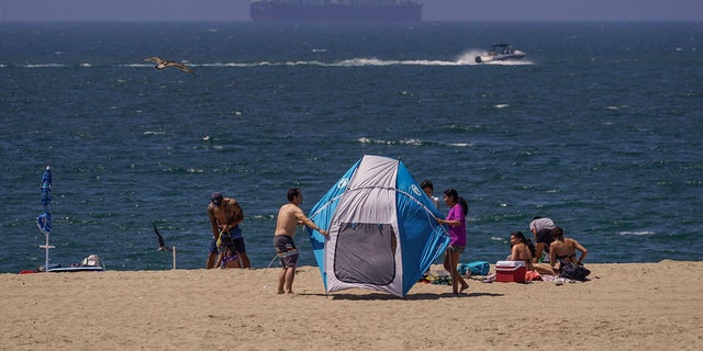 Beach goers hold on to their beach tents