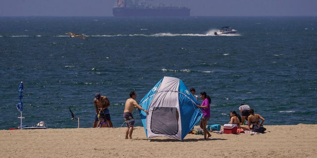 Beach goers hold on to their beach tents