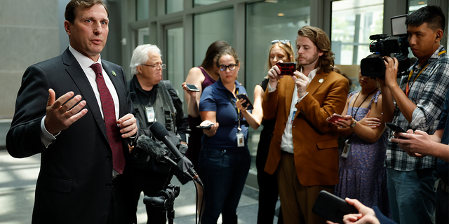 Dan Goldman, left, speaks to press gaggle