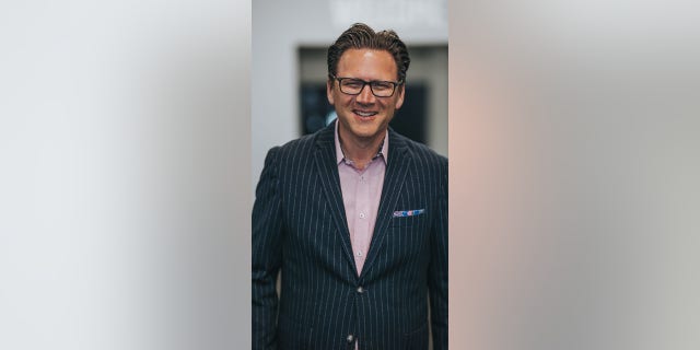 Dr. Brad Jurkovich in striped suit smiling at camera