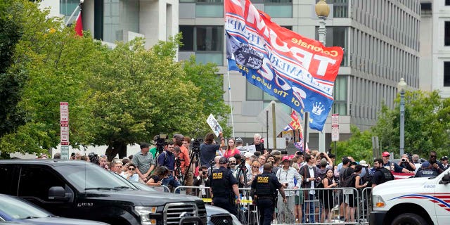 People watch after former President Donald Trump arrived at the E. Barrett Prettyman U.S. Federal Courthouse