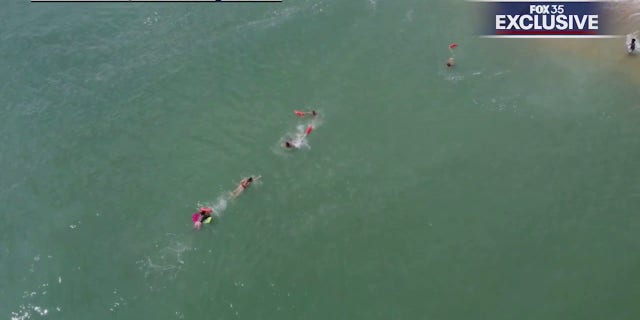 lifeguards swimming to boogie boarder
