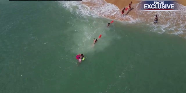 lifeguards and boogie boarder reaching shore