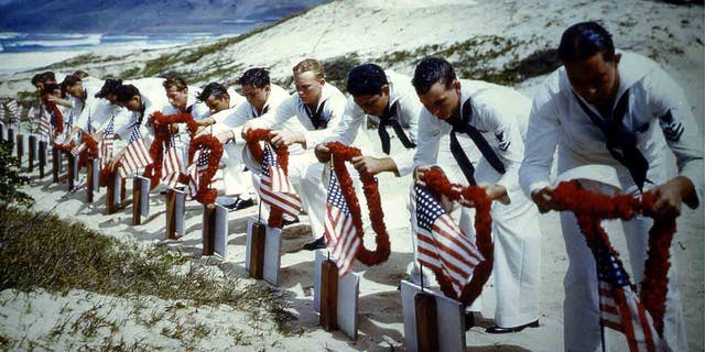 Sailors laying wreaths on graves