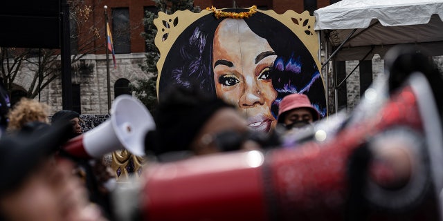 Breonna Taylor poster behind crowd of protesters