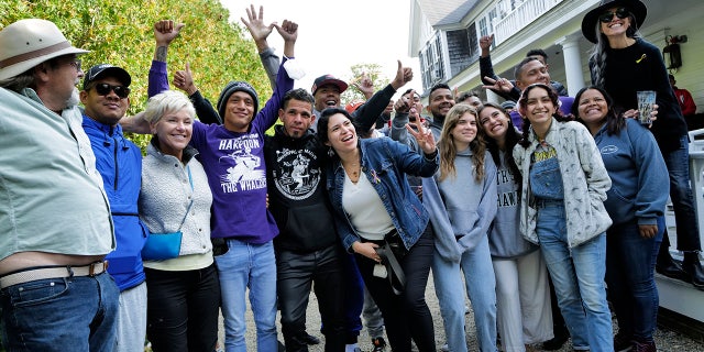 Migrants pose with Martha's Vineyard volunteers