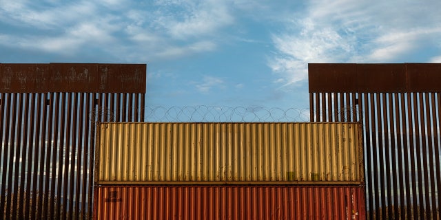 Border wall in Arizona covered with shipping crate