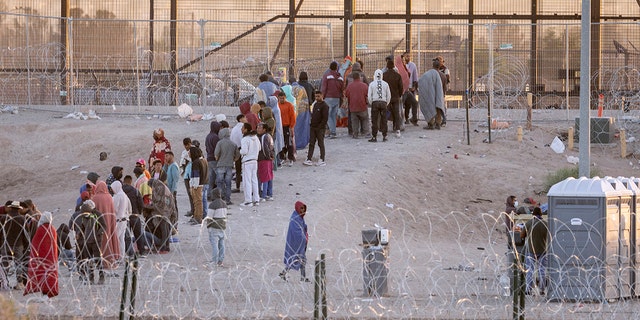 Migrants crowding near the border wall