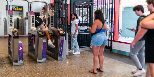 A man jumps over an MTA turnstile