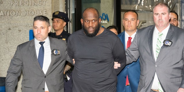 Claude White escorted out of NYPD precinct in handcuffs