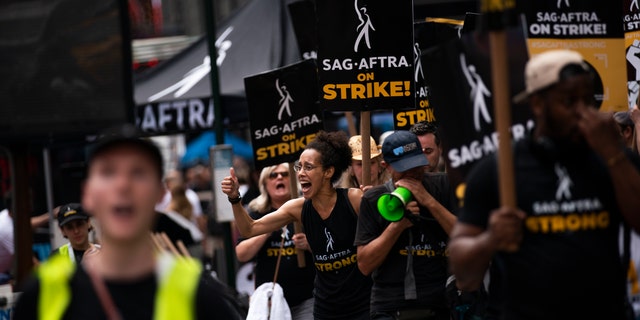 Protesters carrying SAG-AFTRA strike signs