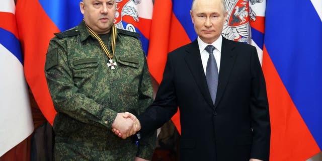 Surovikin and Putin shake hands