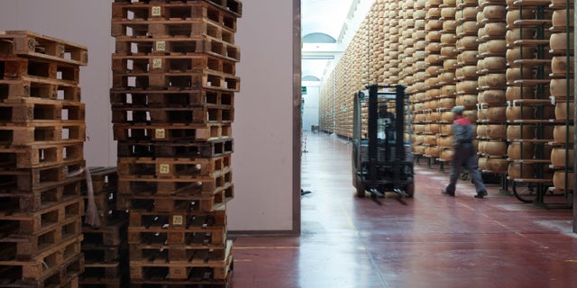 cheese stacked high on shelves in warehouse