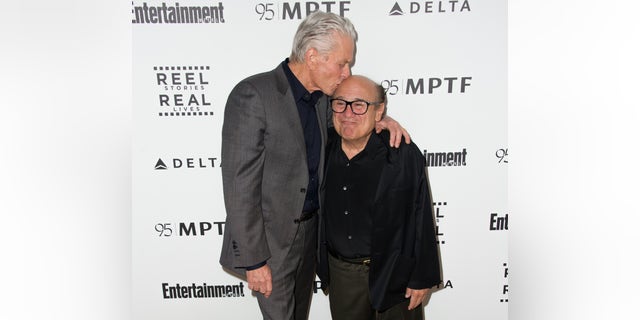 Michael Douglas kisses Danny DeVito on the head