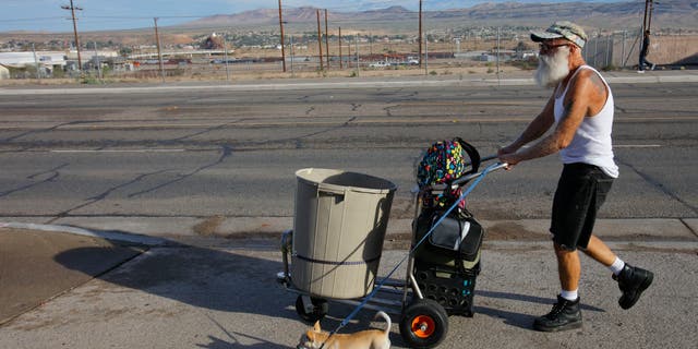 Homeless man shown walking through an arid desert in San Bernardino County