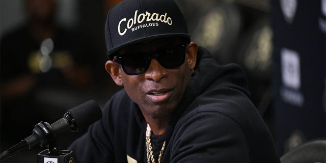 Deion Sanders speaks to reporters