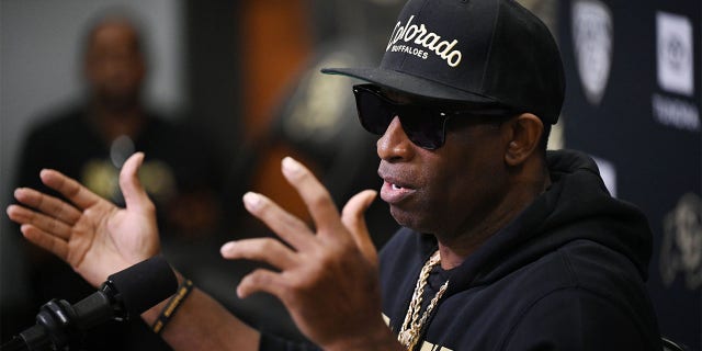 Deion Sanders speaks to reporters