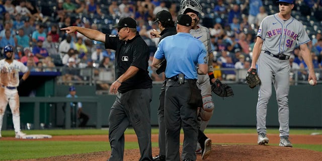 Umpire Marvin Hudson signals home the winning run