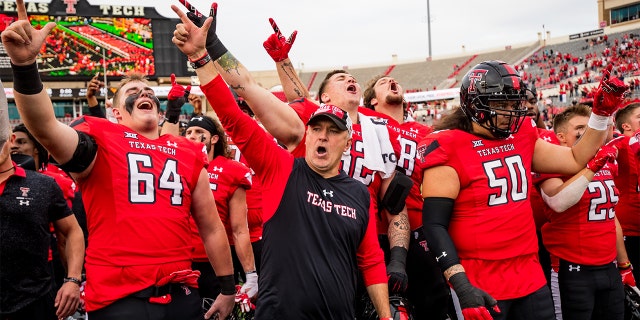 Joey McGuire stands with his players