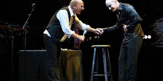 Art Garfunkel and his son smiling on stage and performing together