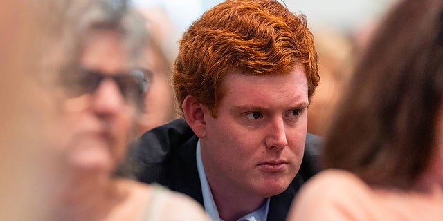 Buster Murdaugh wearing a dark suit and a white shirt as he listens intently