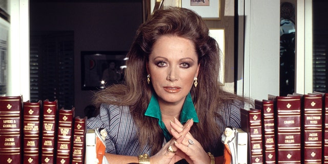 Jackie Collins posing with all the books shes written