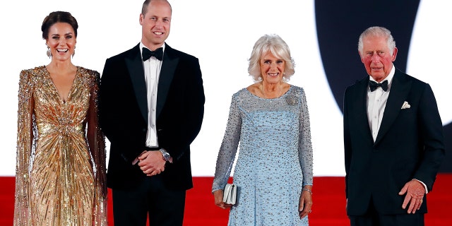 Kate Middleton in a sparkling gold dress standing next to Prince William in a tux, Queen Camilla in a sky blue dress and King Charles III in a tux