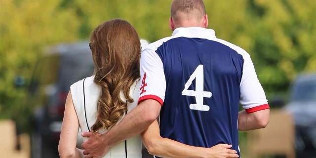 Kate Middleton and Prince William with their backs turned from the camera as they embrace each other