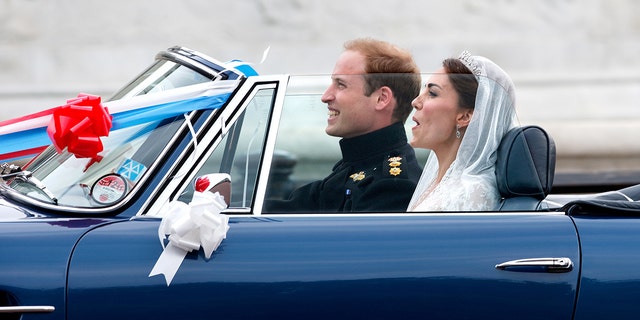 Kate Middleton in a bridal gown sitting in a car next to Prince William on their wedding day