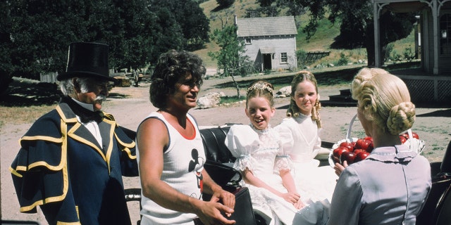 Michael Landon in a Mickey Mouse tank top directing his castmates in costume
