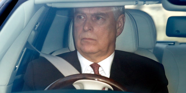 A close-up of Prince Andrew driving in a suit