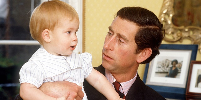 A close-up of Prince Charles holding a baby Prince Harry