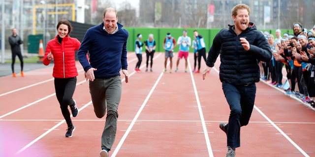 Prince Harry smiling as he runs in a race with Prince William and Kate Middleton