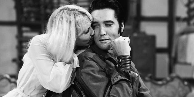 A close-up of Susan Henning kissing Elvis Presleys cheek