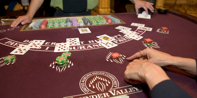 Two people playing Blackjack at a casino