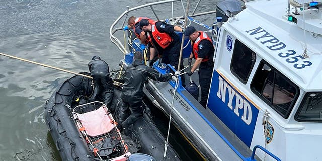 NYPD boats in the water coordinate to lift the body onto the boat