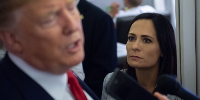 White House Press Secretary Stephanie Grisham listens as President Donald Trump speaks