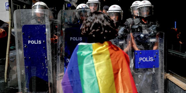A Pride parade goer in front of the police