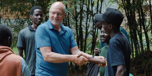 missionary shakes hands another man