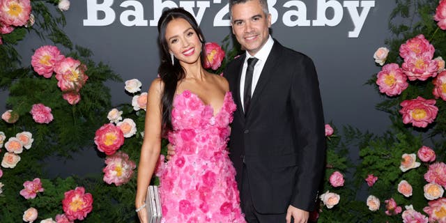Jessica Alba in a pink dress posing with Cash Warren