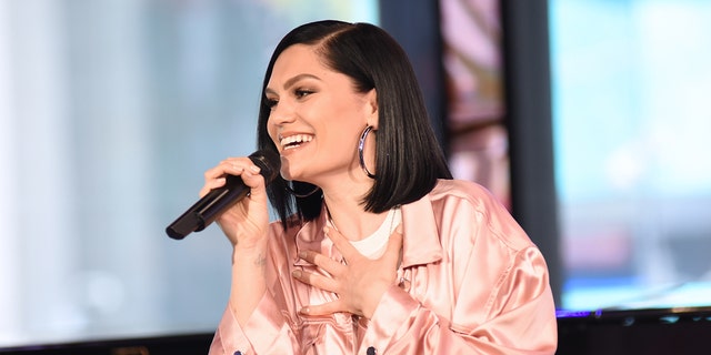 Jessie J on TV holding microphone wearing a pink jacket