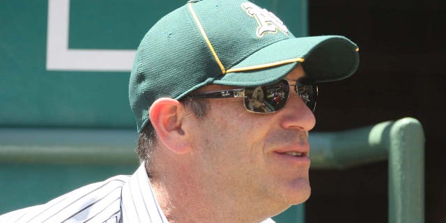 John Fisher watches an Oakland Athletics game