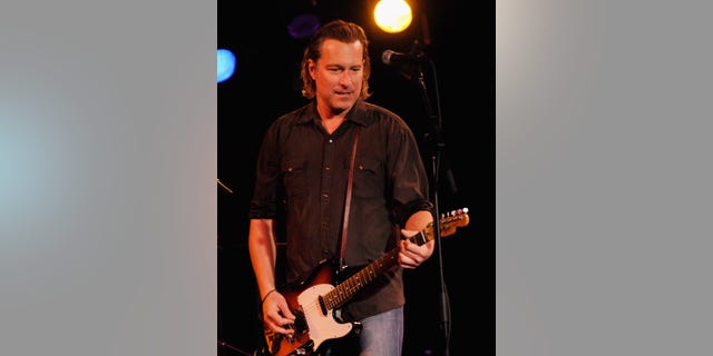 John Corbett plays guitar on stage