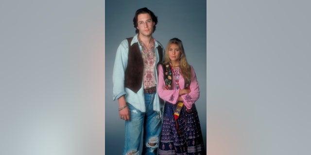 John Corbett in character as a hippie alongside Olivia d'Abo in character as Karen from The Wonder Years