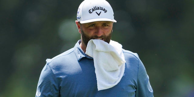 Jon Rahm walks down with towel