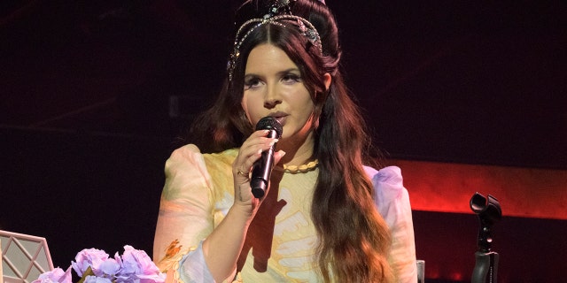 Lana Del Rey holds a microphone on stage