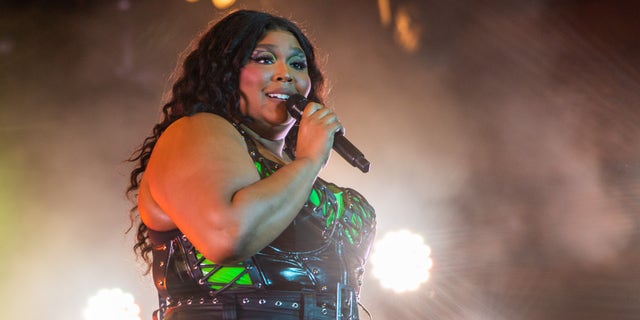 Lizzo performing on stage with a microphone