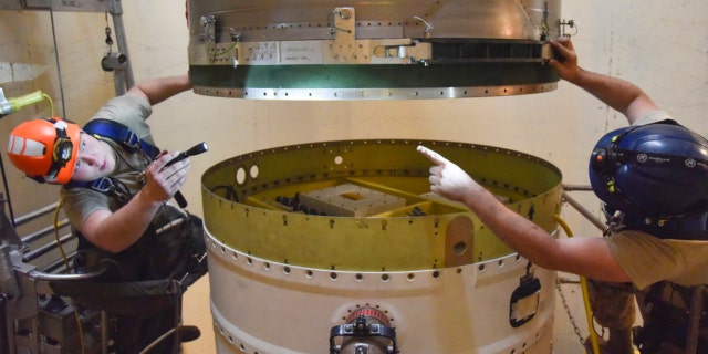 341st Missile Maintenance Squadron technicians connect a re-entry system to a spacer on an intercontinental ballistic missile