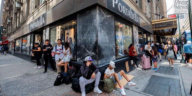 Migrants sitting on Manhattan street corner